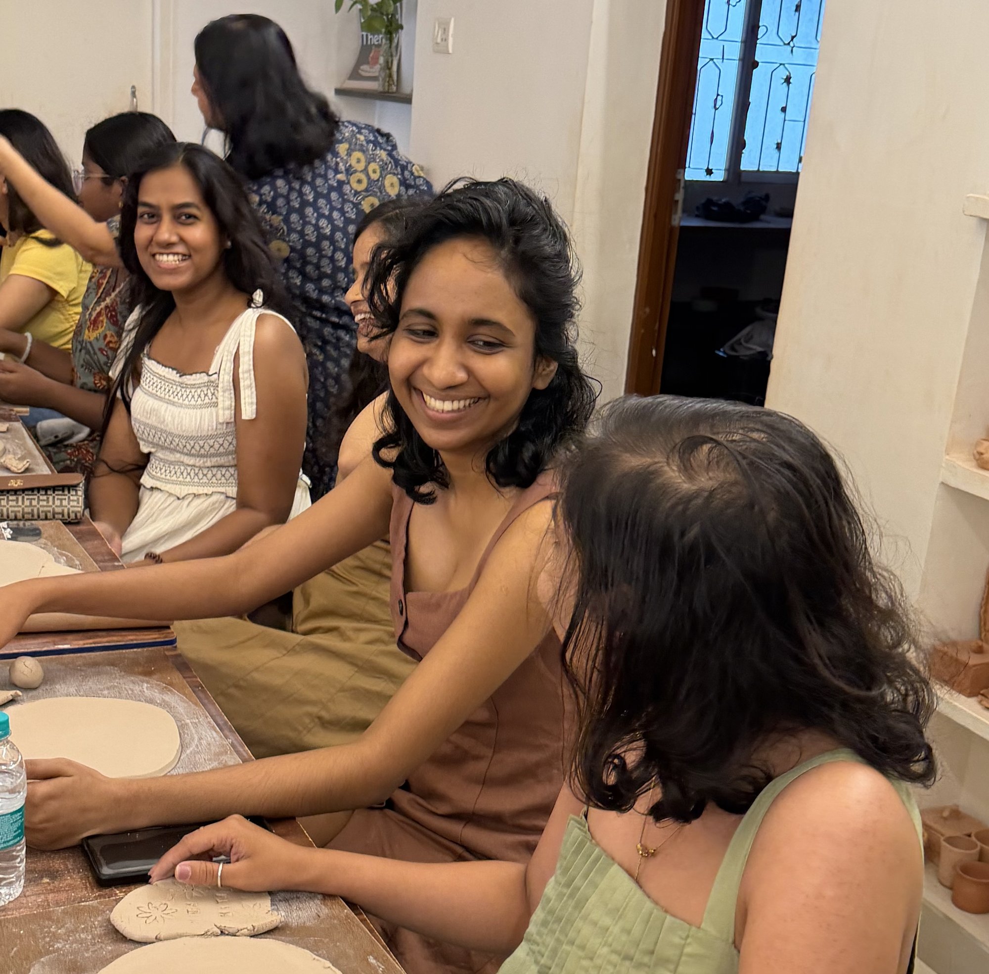 Four members posing together at a ceramics studio