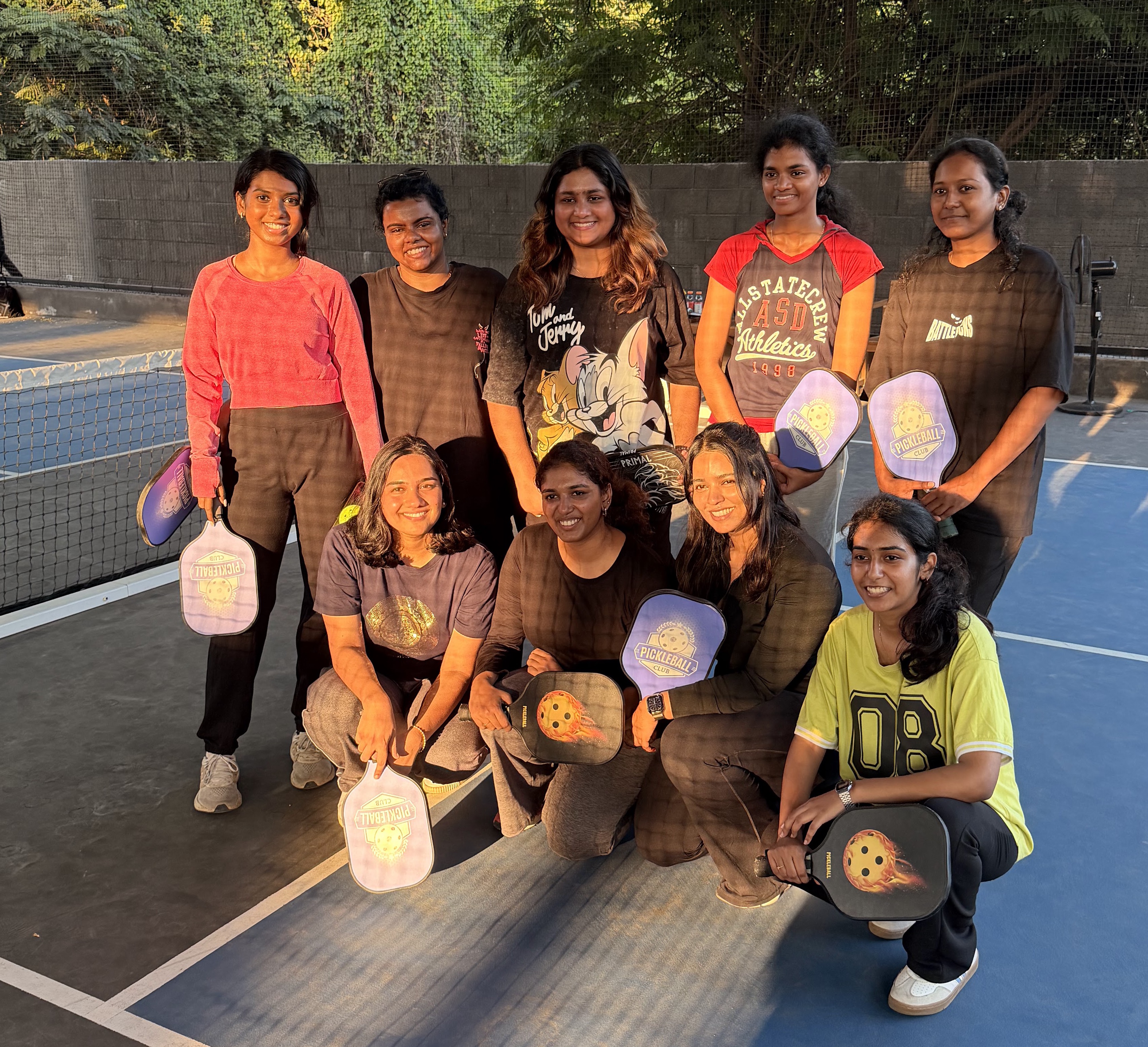 Two members laughing with pickleball paddles